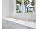 Well-lit bathroom with quartz countertops and dual sinks with a scenic outdoor view at 1575 Eastbrook Dr, Sarasota, FL 34231