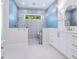 Luxurious bathroom featuring a standalone tub, blue tile and custom cabinets at 1575 Eastbrook Dr, Sarasota, FL 34231