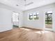 Light-filled bedroom showcasing hardwood floors, sliding barn door and views of the backyard pool at 1575 Eastbrook Dr, Sarasota, FL 34231