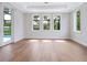 Bedroom with hardwood floors and multiple windows overlooking the pool at 1575 Eastbrook Dr, Sarasota, FL 34231