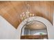 Elegant foyer chandelier with wood ceiling and front door view at 1575 Eastbrook Dr, Sarasota, FL 34231