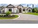 Beautiful exterior elevation showcasing stone accents, a tile roof, and a circular driveway with lush landscaping at 1575 Eastbrook Dr, Sarasota, FL 34231