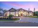 Stunning stone home with manicured landscaping, elegant lighting, and a paver driveway leading to a welcoming entrance at 1575 Eastbrook Dr, Sarasota, FL 34231