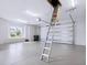 Spacious two-car garage featuring clean epoxy flooring, storage ladder, and plentiful natural light from a window at 1575 Eastbrook Dr, Sarasota, FL 34231