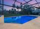 Gorgeous in-ground pool with a screened enclosure surrounded by palm trees and green landscape at 1575 Eastbrook Dr, Sarasota, FL 34231