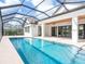 The crystal blue screened pool showcases an attached spa and an expansive outdoor living space at 1575 Eastbrook Dr, Sarasota, FL 34231