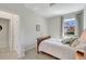 Bright bedroom with wooden bed frame, neutral carpet, and window views of the landscaped yard at 17042 Hampton Falls Ter, Bradenton, FL 34202