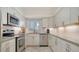 Bright kitchen boasting stainless steel appliances, stone countertops, and white cabinetry at 1711 Southwood St # 1711, Sarasota, FL 34231