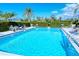 This beautiful clear blue pool is lined with ample seating and lush green bushes and plants at 1711 Southwood St # 1711, Sarasota, FL 34231