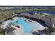 Stunning aerial view of a resort-style community pool, clubhouse, and lush landscaping with ponds and seating areas at 177 Tierra Verde Way, Bradenton, FL 34212
