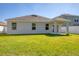 Back exterior featuring a covered porch, well-maintained lawn and several windows at 177 Tierra Verde Way, Bradenton, FL 34212