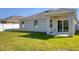 Back exterior featuring a covered porch, well-maintained lawn and sliding glass doors at 177 Tierra Verde Way, Bradenton, FL 34212