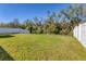 Large, grassy backyard enclosed by a combination of white vinyl and black metal fencing at 177 Tierra Verde Way, Bradenton, FL 34212