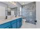 Modern bathroom with blue vanity, double sinks, and a striking tiled shower area at 177 Tierra Verde Way, Bradenton, FL 34212
