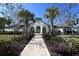 Elegant clubhouse entrance with a brick walkway, lush landscaping, and an inviting arched doorway at 177 Tierra Verde Way, Bradenton, FL 34212