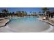 Large community pool surrounded by palm trees and lounge chairs, perfect for relaxation and outdoor enjoyment at 177 Tierra Verde Way, Bradenton, FL 34212