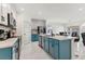 Open kitchen featuring blue cabinets, white countertops, and an island with seating flowing into dining area at 177 Tierra Verde Way, Bradenton, FL 34212