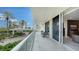 A long condo balcony with an open outdoor view, comfortable furniture, and amazing natural light and open space at 1800 Benjamin Franklin Dr # B208, Sarasota, FL 34236