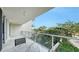A spacious balcony features stylish marble floors and clear glass railings with treetop views at 1800 Benjamin Franklin Dr # B208, Sarasota, FL 34236