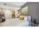 Cozy bedroom featuring a gray accent wall, en-suite bathroom, and a comfortable bed with stylish decor at 1800 Benjamin Franklin Dr # B208, Sarasota, FL 34236