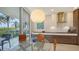 A chic dining area with views from sliding glass doors; modern pendant lighting at 1800 Benjamin Franklin Dr # B208, Sarasota, FL 34236