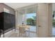 Bright home office with a standing desk, storage, and a sliding glass door to a balcony with beautiful views at 1800 Benjamin Franklin Dr # B208, Sarasota, FL 34236