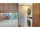 Modern laundry area with a stackable washer/dryer and built-in ironing board at 1800 Benjamin Franklin Dr # B208, Sarasota, FL 34236