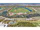 Expansive aerial view of community featuring lush golf courses, tennis courts, sparkling pool, and rows of beautiful homes at 18117 Gawthrop Dr # 101, Lakewood Ranch, FL 34211