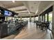 Modern bar and lounge area with a large counter, comfortable seating, and multiple TVs for entertainment at 18117 Gawthrop Dr # 101, Lakewood Ranch, FL 34211