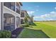 Beautiful rear exterior with lush green lawn and view of the screened lanais at 18117 Gawthrop Dr # 101, Lakewood Ranch, FL 34211