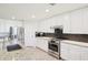 Bright kitchen features stainless steel appliances, white cabinets and granite countertops at 18117 Gawthrop Dr # 101, Lakewood Ranch, FL 34211