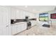 Kitchen with white cabinets, granite counters, stainless steel appliances and dark backsplash at 18117 Gawthrop Dr # 101, Lakewood Ranch, FL 34211