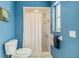 Bathroom featuring blue walls and white shower, toilet, and tile at 1878 Killdeer Ct, Venice, FL 34293
