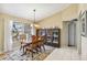 Dining room with chandelier and large window and a wooden table and china cabinet at 1878 Killdeer Ct, Venice, FL 34293