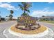Community entrance to Quail Lake with stone sign and beautiful landscaping at 1878 Killdeer Ct, Venice, FL 34293