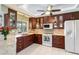 Kitchen with granite countertops, stainless steel appliances, and dark wood cabinets at 1878 Killdeer Ct, Venice, FL 34293