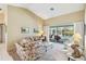 Living room with neutral tones, plush seating, and sliding doors to a screened lanai at 1878 Killdeer Ct, Venice, FL 34293