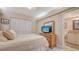 Bedroom with a TV, wood dresser, and an ensuite bathroom at 1925 Gulf Of Mexico Dr # G8-206, Longboat Key, FL 34228