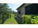 Well-maintained backyard with lush grass, fencing, and manicured landscaping at 20186 Benissimo Dr, Venice, FL 34293