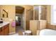 Bright and roomy bathroom features a glass shower, soaking tub, and convenient access to the bedroom at 20186 Benissimo Dr, Venice, FL 34293
