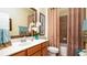 Well-lit bathroom with a vanity, decorative mirror, and a shower-tub combination with a stylish curtain at 20186 Benissimo Dr, Venice, FL 34293