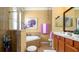 Well-lit bathroom with a soaking tub, glass-enclosed shower, wooden cabinets, and decorative touches at 20186 Benissimo Dr, Venice, FL 34293