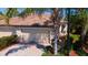 Two-car garage home exterior featuring a tile roof, brick driveway, and well-maintained landscaping at 20186 Benissimo Dr, Venice, FL 34293