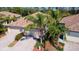 Aerial view of the villa with a tile roof, and lush landscaping, with a brick driveway at 20186 Benissimo Dr, Venice, FL 34293