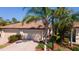 Home exterior displaying a two-car garage, tile roof, brick driveway, and neat landscaping at 20186 Benissimo Dr, Venice, FL 34293