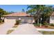 Charming home featuring a two-car garage, tile roof, brick driveway, and well-maintained landscaping at 20186 Benissimo Dr, Venice, FL 34293