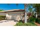 Attached two-car garage with brick-paved driveway, and well-maintained landscaping at 20186 Benissimo Dr, Venice, FL 34293