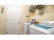 Functional laundry room with washer, dryer, storage shelves, and ample space for cleaning supplies at 20186 Benissimo Dr, Venice, FL 34293