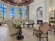 Bright living room features tall windows, comfortable seating, and a cozy fireplace, creating an inviting atmosphere at 20186 Benissimo Dr, Venice, FL 34293