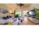 Cozy living room with a ceiling fan, tile floors, and access to a screened-in patio provides a comfortable atmosphere at 20186 Benissimo Dr, Venice, FL 34293